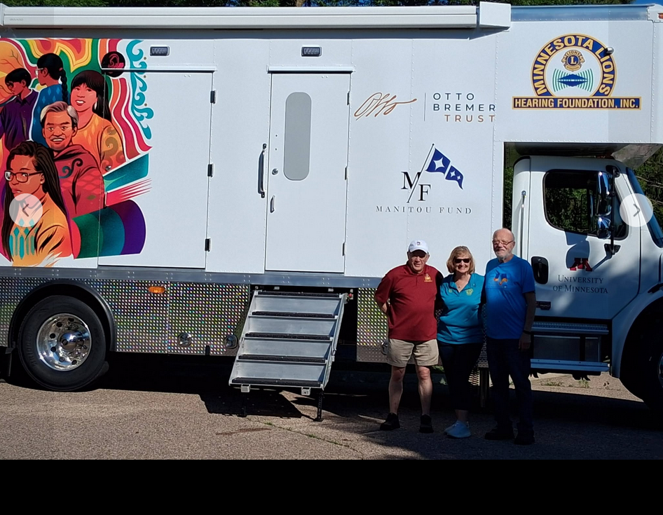 PDG Mike Appel, DGE Diann Bellmont, and Lion Bob Harms in front of the mobile hearing unit